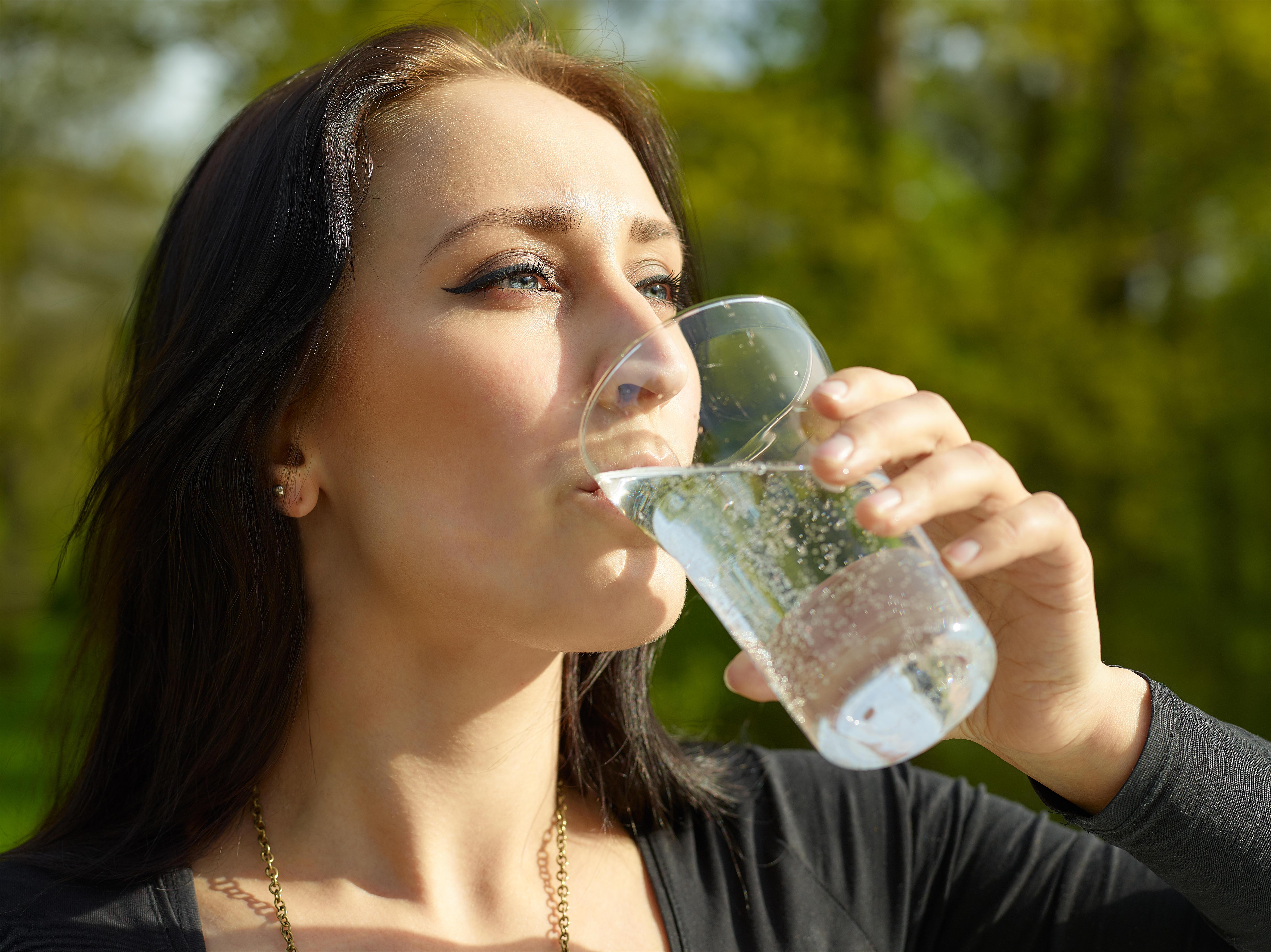 Что будет если пить минералку. Женщина пьет воду. Девушка со стаканом воды. Человек пьет газированную воду. Девушка пьет минеральную воду.